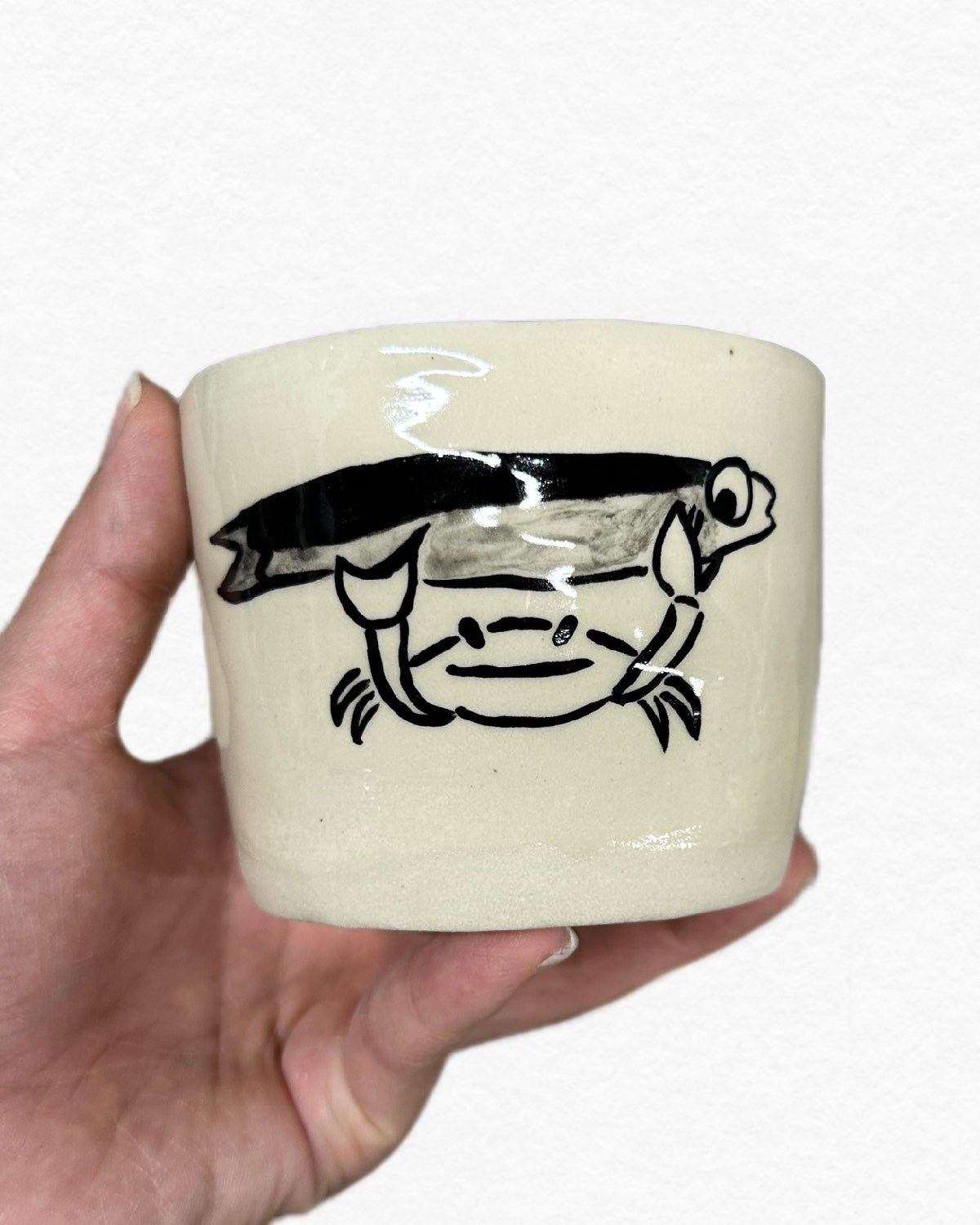 crab holding fish - cup